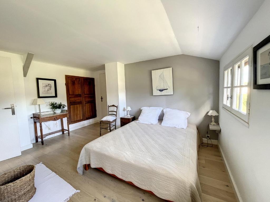 a bedroom with a bed with white sheets and a desk at Maison Saint-Pair-sur-Mer, 5 pièces, 8 personnes - FR-1-361-56 in Saint-Pair-sur-Mer