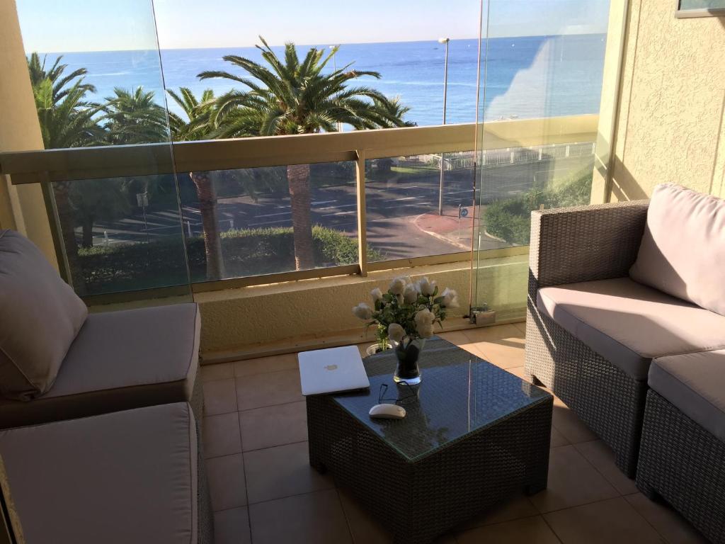 - un salon avec une table et une vue sur l'océan dans l'établissement Dionysos Vue Mer, à Cannes