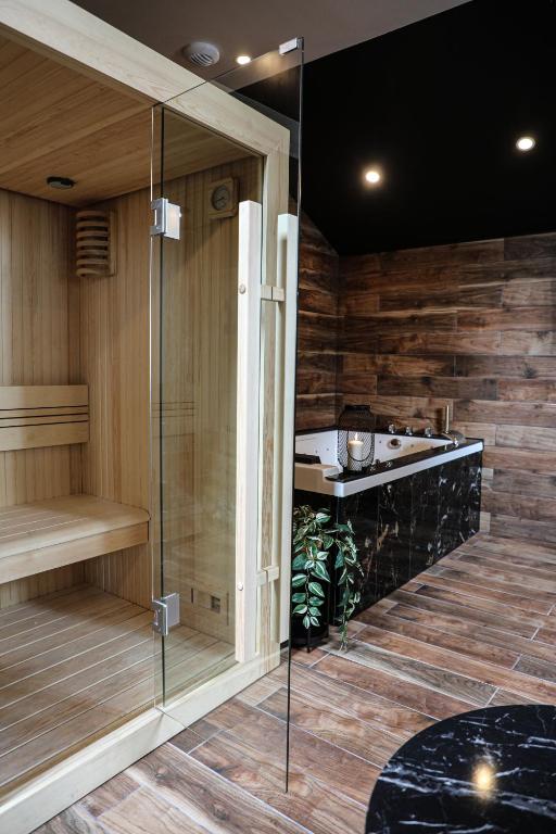 un sauna avec une douche en verre et un lavabo dans l'établissement Le Premium - Suite Spa Privatif, à Pontavert