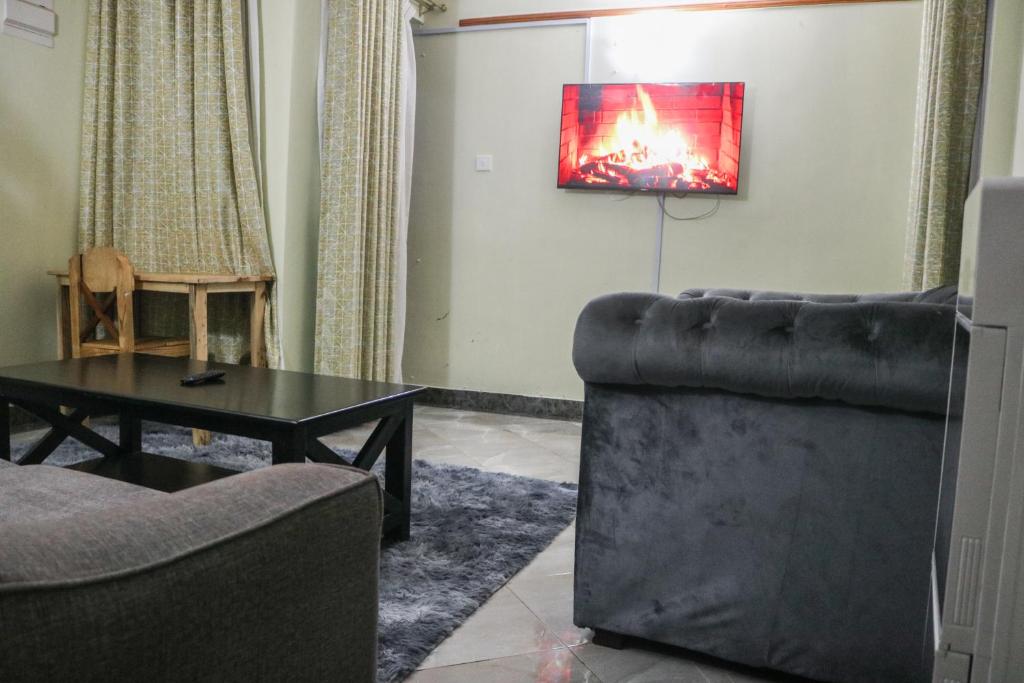 sala de estar con sofá y mesa en Zedek Furnished Apartment 203, en Nairobi