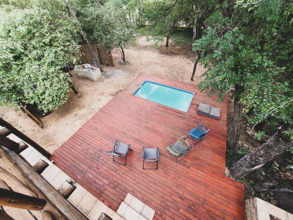 vista sul soffitto di una piscina con 2 sedie di HUIS ASEM a Marloth Park