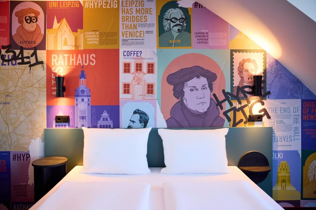 Dormitorio con cama con posters en la pared en McDreams Hotel Leipzig, en Leipzig