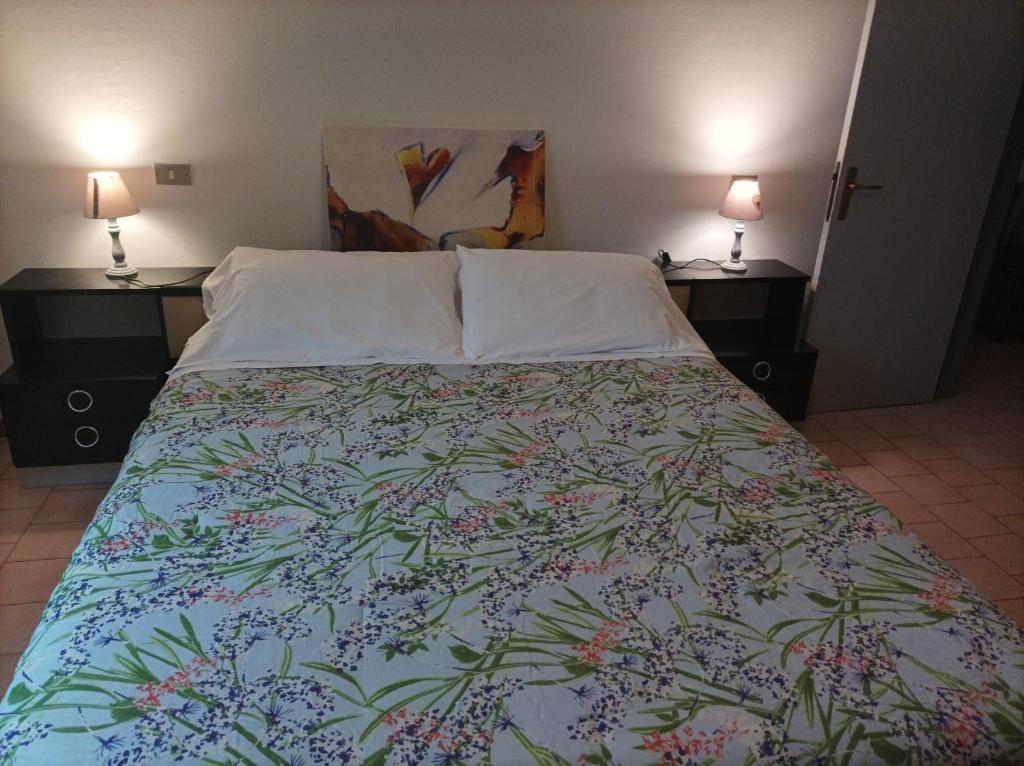 łóżko z kolorowym kocem z dwoma stolikami nocnymi w obiekcie MicaMatti near Maranello w mieście Castelnuovo Rangone