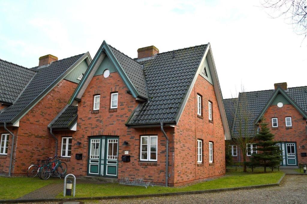 een groot gebouw van rode baksteen met zwarte daken bij Green Eilun - Hausteil 5 in Wyk auf Föhr