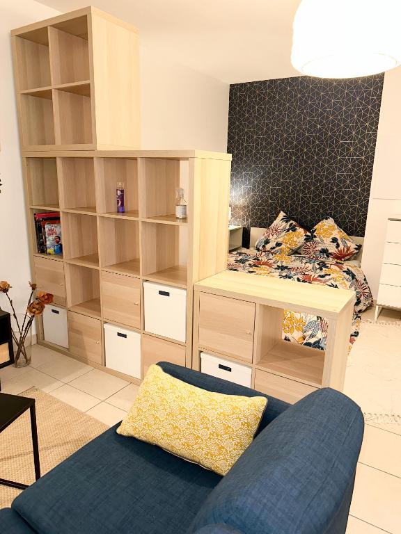1 dormitorio con 1 cama y 1 sofá azul en « Le Cosy » Cergy le Haut RER A, en Cergy