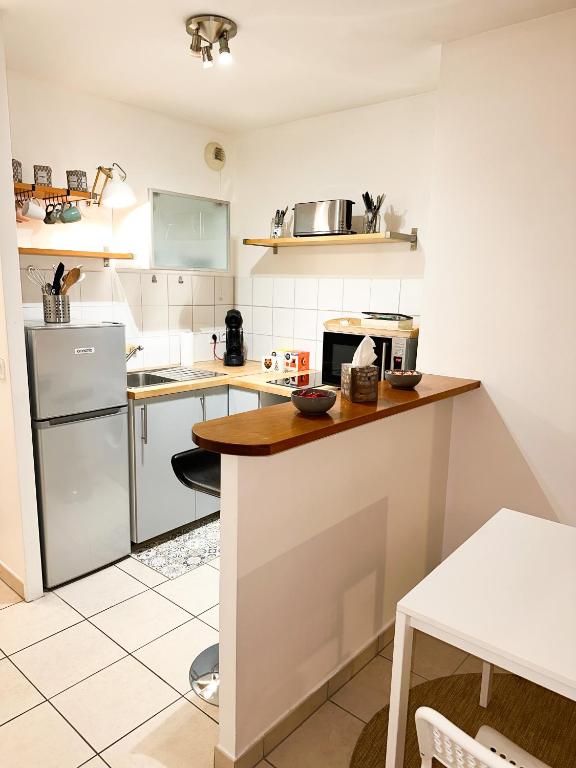 una pequeña cocina con encimera y nevera en « Le Cosy » Cergy le Haut RER A, en Cergy