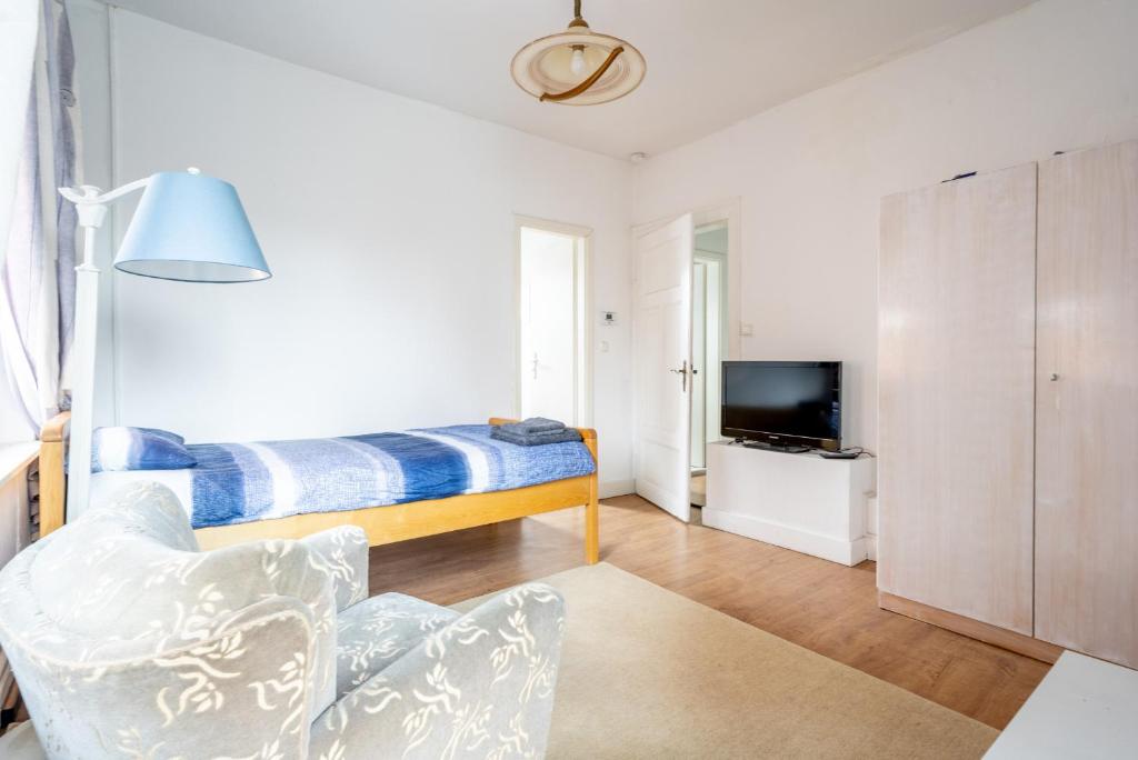 een kamer met een bed, een stoel en een tv bij Private Apartment in Hannover