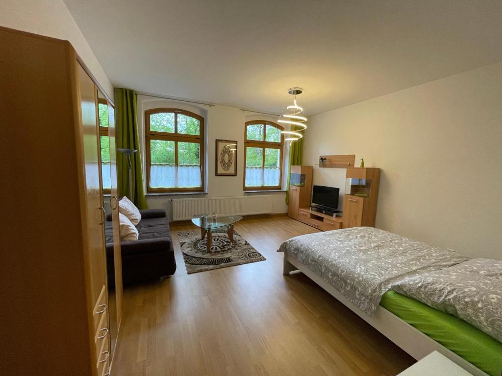 - une chambre avec un lit et un salon dans l'établissement Ferienwohnung im Zentrum Zwickaus, à Zwickau
