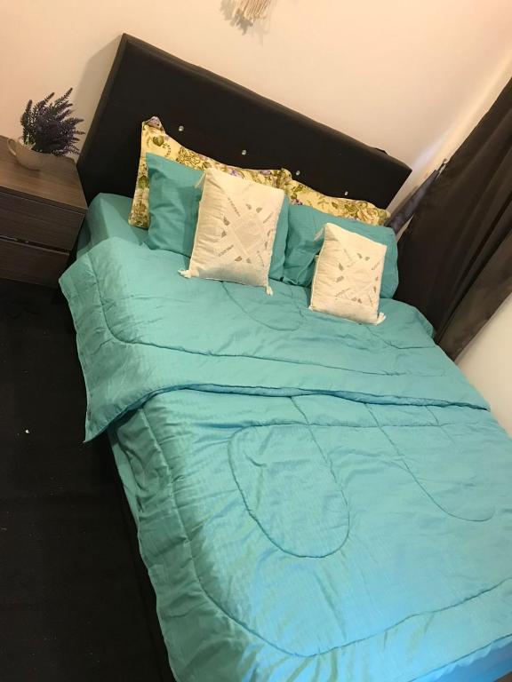 a bed with blue sheets and pillows on it at Palas Horizon in Kabus in Brinchang