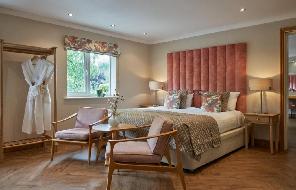 a bedroom with a bed and a table and chairs at Fairlawns, Hotel And Spa in Walsall