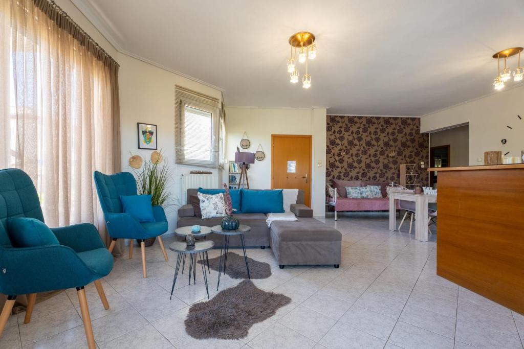 un soggiorno con sedie blu e un divano di Estell’s sweet luxury house a Volos