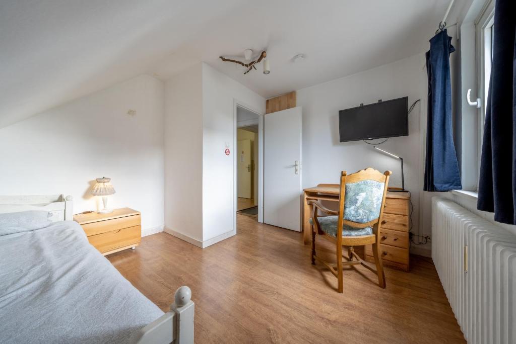 Schlafzimmer mit einem Schreibtisch, einem Bett und einem Stuhl in der Unterkunft Private Apartment in Hannover