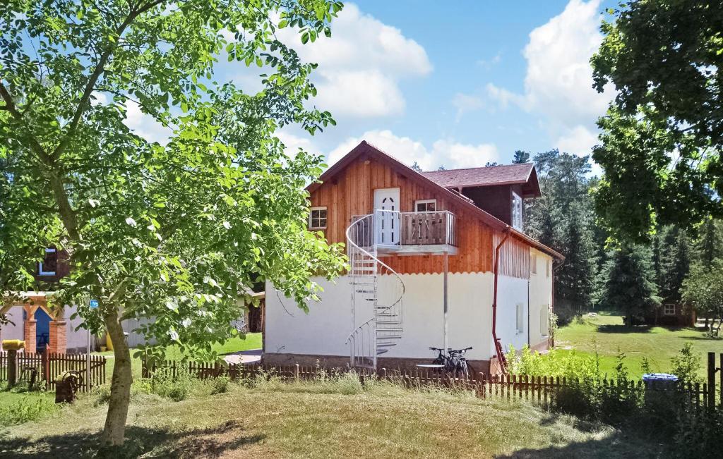 a small house with a balcony and a tree at 1 Bedroom Pet Friendly Apartment In Grnow in Grünow
