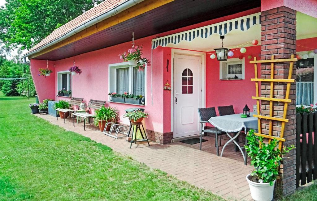 Casa rosa con mesa y sillas en el patio en Cozy Home In Altglobsow With Kitchen, en Altglobsow