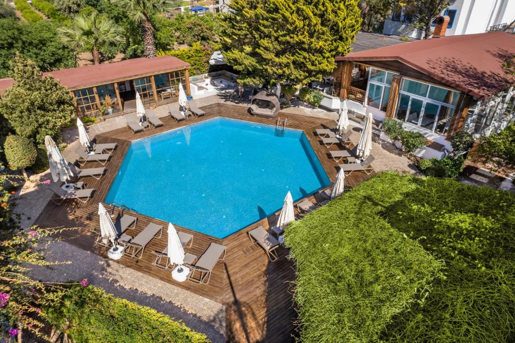 - une vue sur la piscine avec des chaises et une maison dans l'établissement Costa Bodrum City, à Bodrum City
