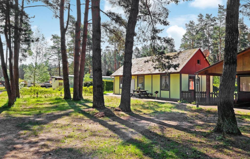 una casa roja y amarilla en el bosque en Beautiful stacaravan In Rheinsberg Ot Kagar With Kitchen, en Kagar
