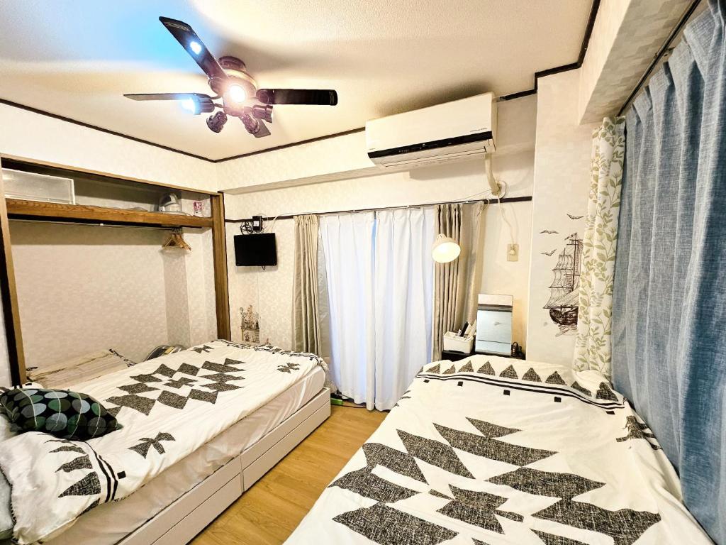 a bedroom with two beds and a ceiling fan at Downtown Tokyo/Taito-gu/2min walk nearest sta/Ueno/Wi-Fi/302 in Tokyo