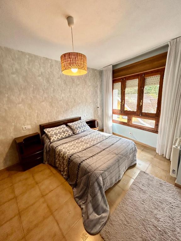 a bedroom with a bed and a large window at Del Valle 3 in Cudillero