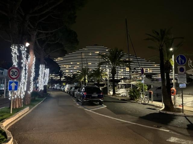 une rue de la ville la nuit avec de grands bâtiments dans l'établissement Studio-cabine 4p Marina Baie des Anges, à Villeneuve-Loubet