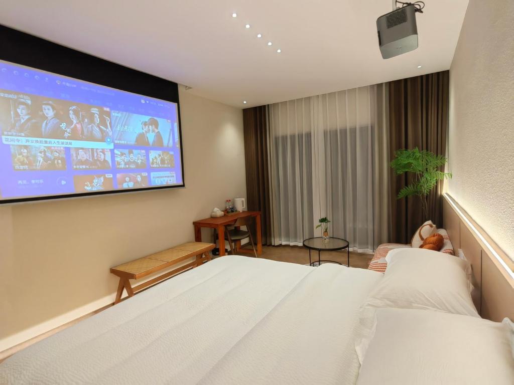 a hotel room with a bed and a projection screen at Flower Whisperer Homestay Tianmenshan Store free airport and station pick-up in Zhangjiajie