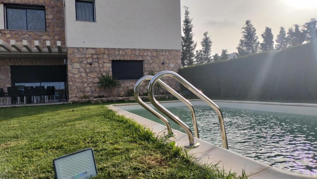 a sculpture in front of a house next to a body of water at L'Écrin de Paradis in Sousse