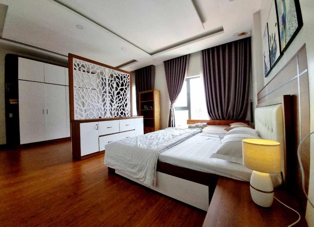 a bedroom with a large bed and a large window at Biệt thự Thu Le in Ho Chi Minh City