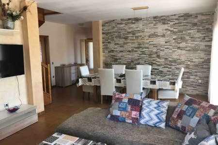 a living room with a couch and a stone wall at Casa Bellavista con piscina en Caldes Costa Brava in Caldes de Malavella