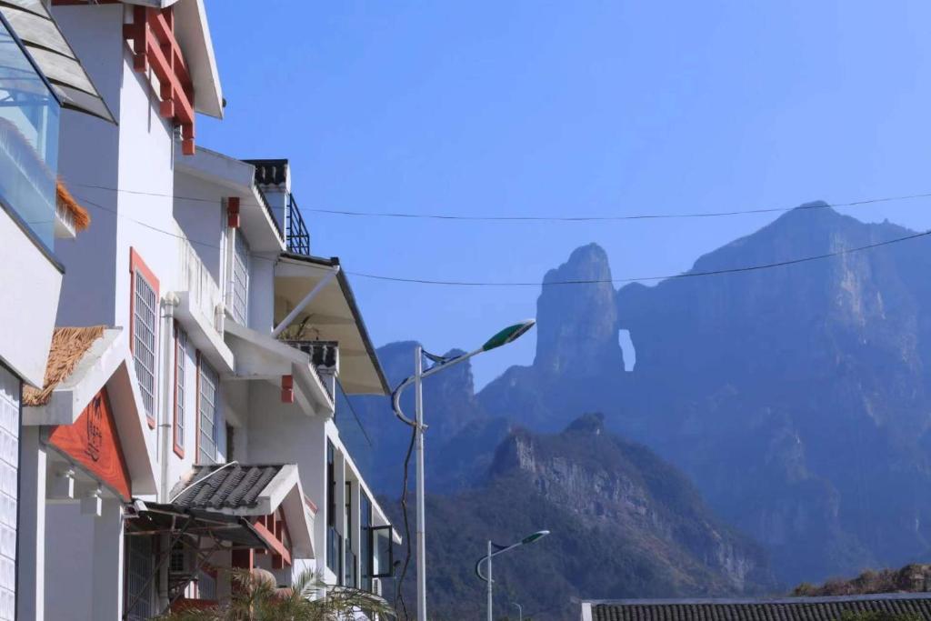 a view of the mountains from between buildings at Flower Whisperer Homestay Tianmenshan Store free airport and station pick-up in Zhangjiajie