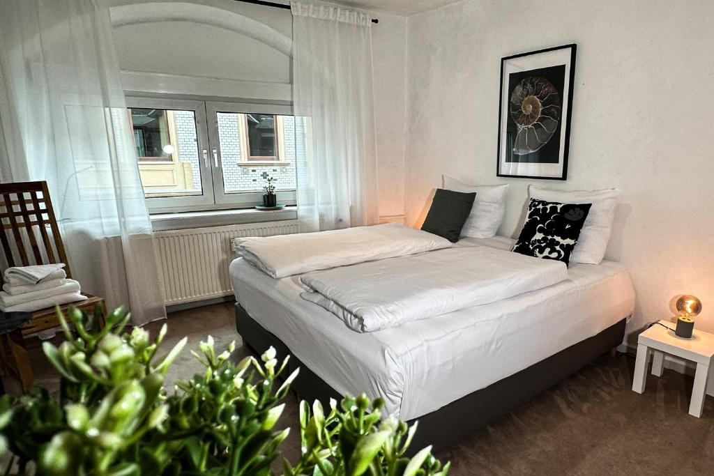 - une chambre avec un lit blanc et une fenêtre dans l'établissement Stadtoase nähe Uni Design Wohnung mit 2 Schlafzimmern & Sauna, à Coblence