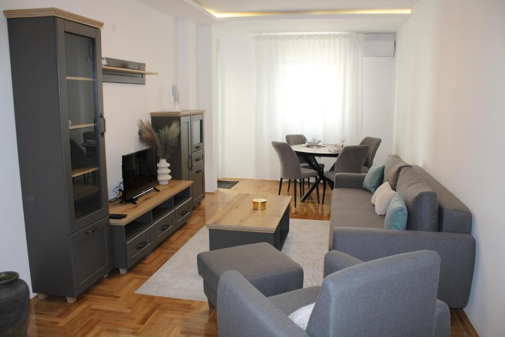 a living room with a couch and a tv at Apartment M in Smederevo