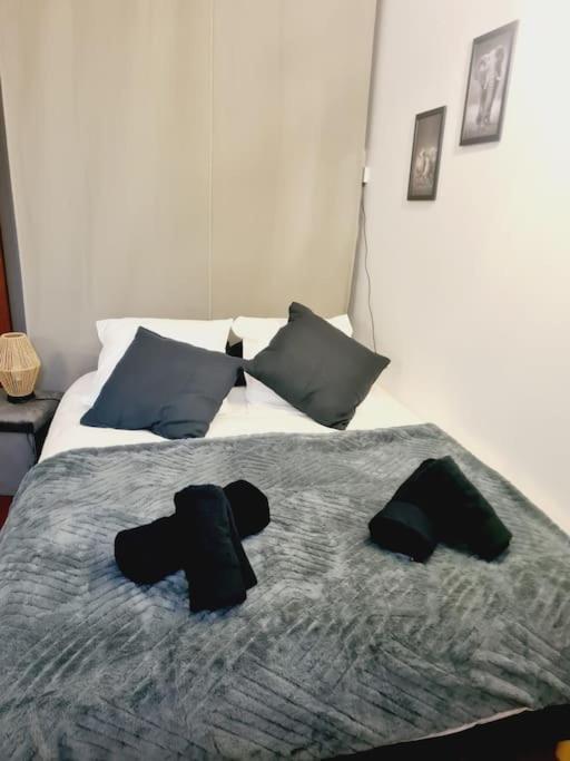 - une chambre avec un lit doté de deux chapeaux noirs dans l'établissement L'anjou - St Nazaire - Comme à la maison, à Saint-Nazaire