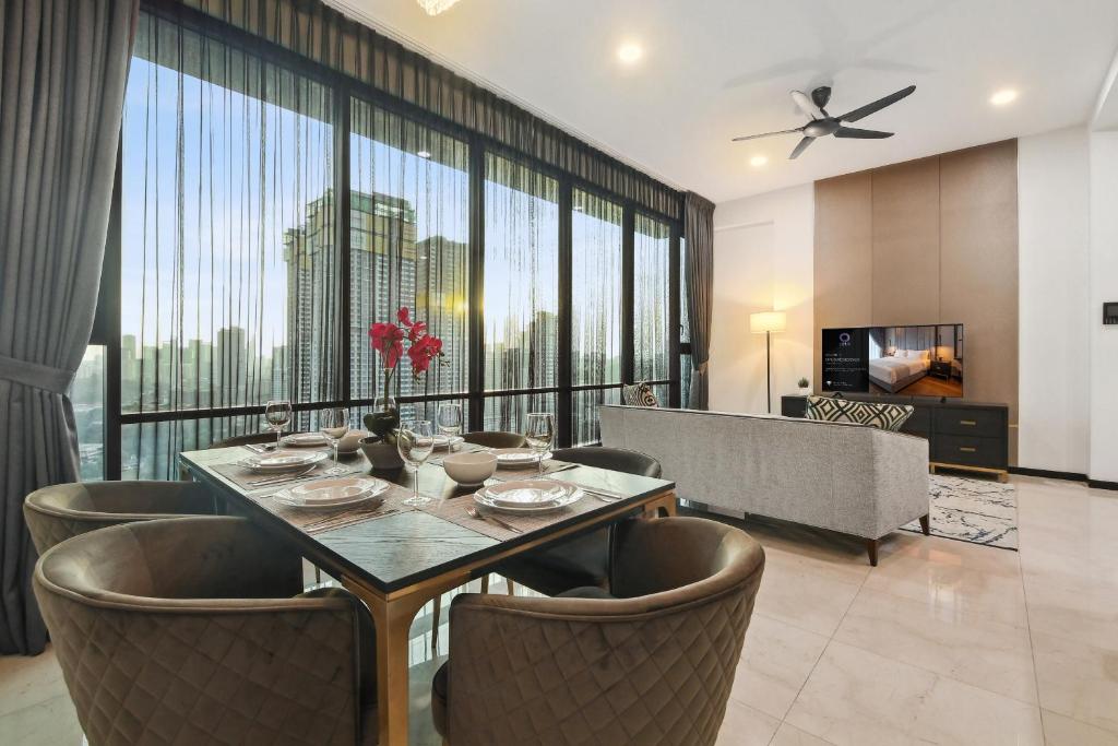 uma sala de jantar com mesa e cadeiras e uma grande janela em Opus Residences by Opus Hospitality em Kuala Lumpur