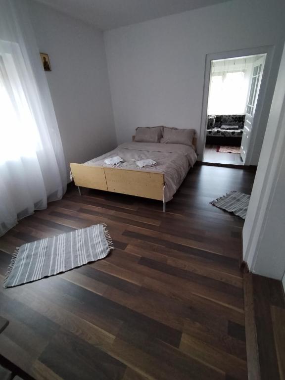 1 dormitorio con 1 cama y suelo de madera en Apartament la casa pe Transrarau en Pojorîta