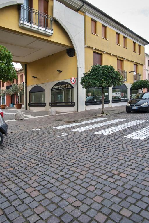 a building with cars parked in front of a street at Condominio Maria Ida in Caorle