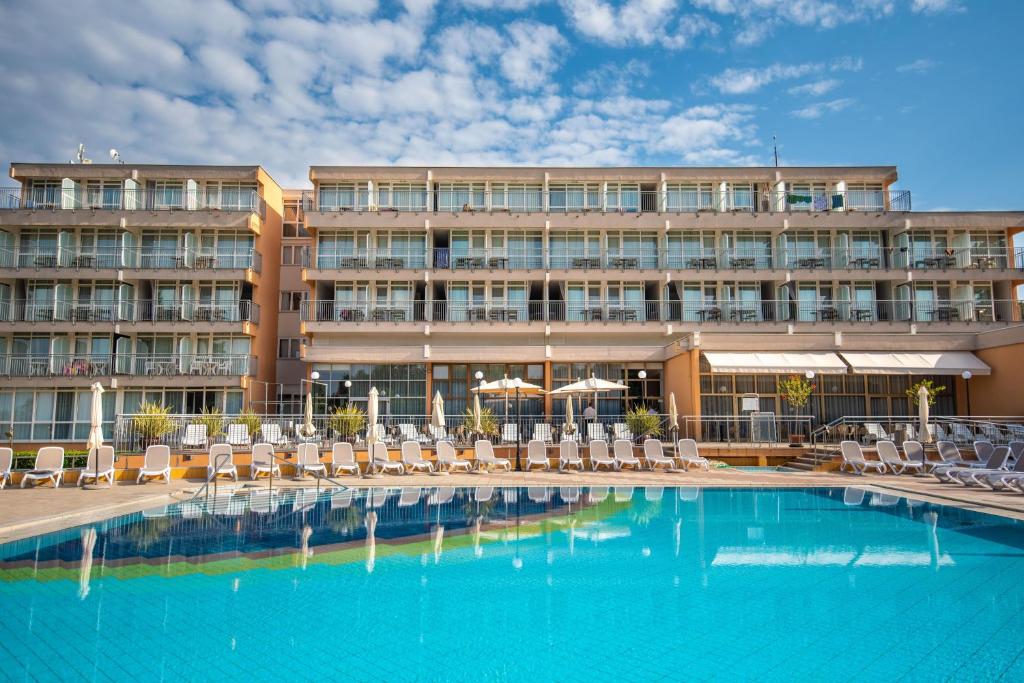un hotel con piscina, sillas y un edificio en Arena Hotel Holiday en Medulin