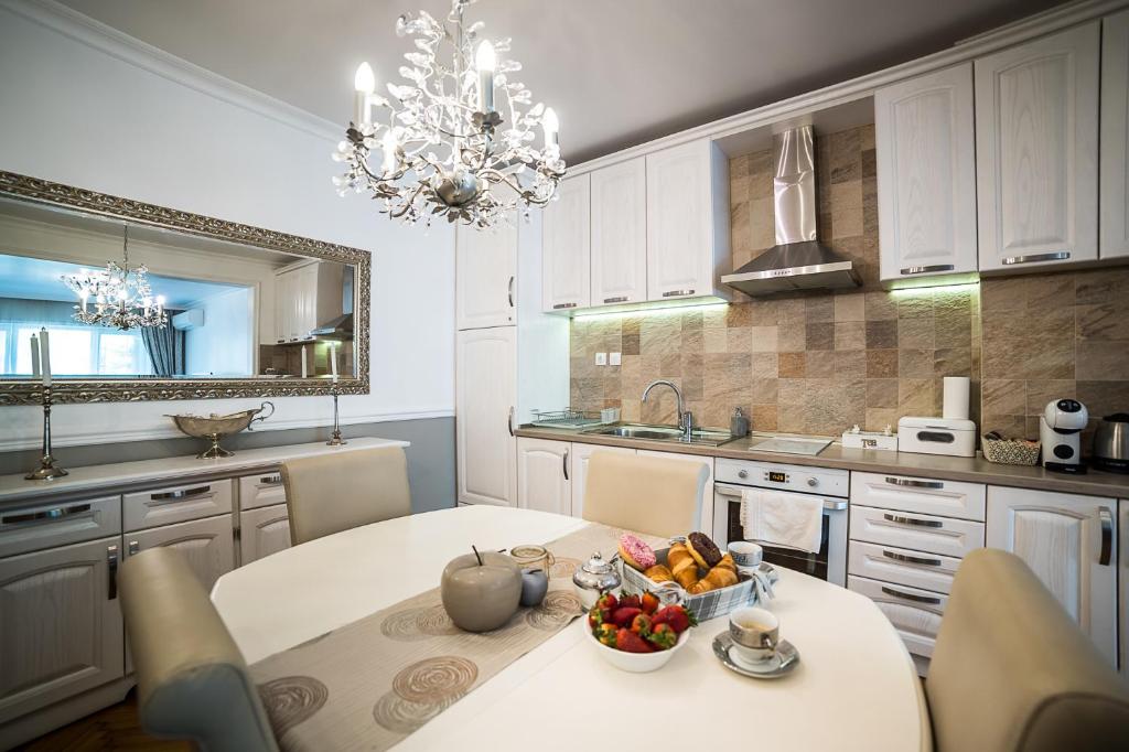 a kitchen with a table with a bowl of fruit on it at Apartment Antique Theatre in Stara Zagora