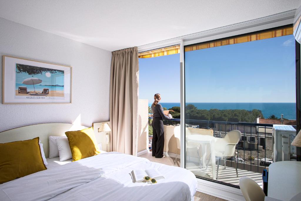 a hotel room with a bed and a balcony at Hotel Centre Plage in Argelès-sur-Mer