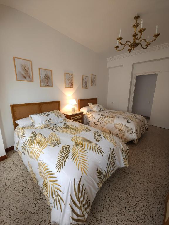 a bedroom with two beds and a chandelier at La Panaderia 8 PAX, terraza exterior in Cenicero