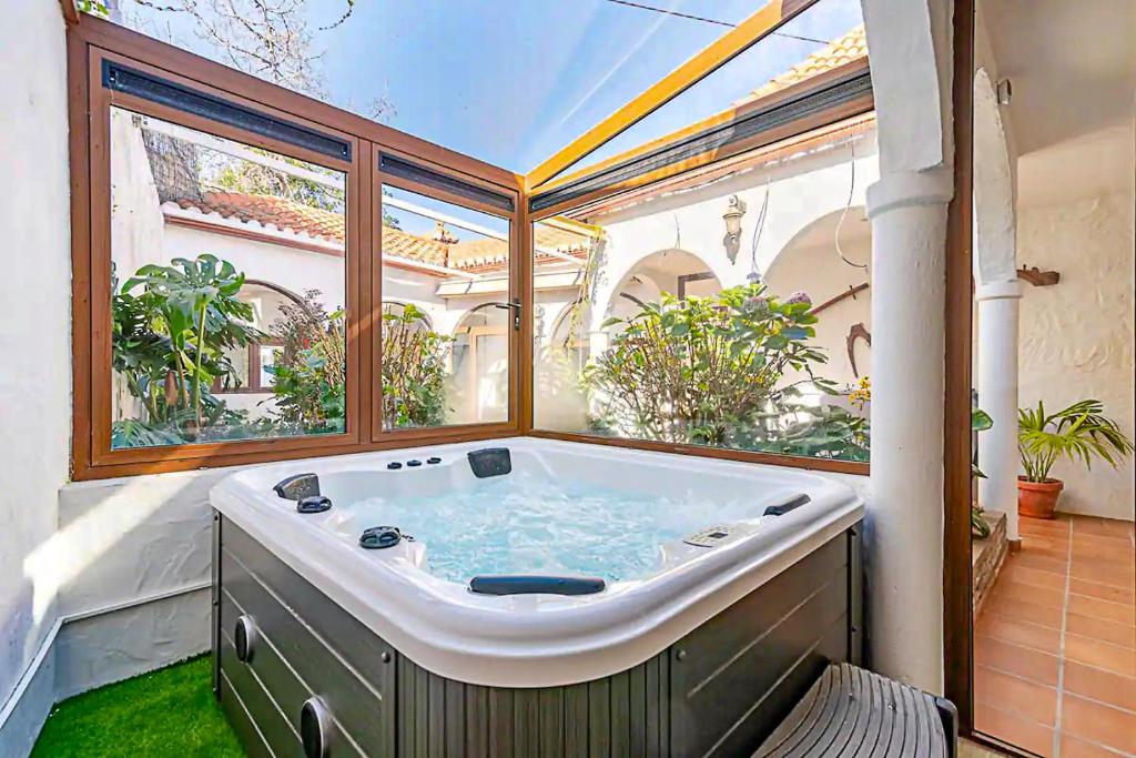 a large bath tub in a room with a large window at Casa típica canaria en el Parque Rural de Doramas in Teror