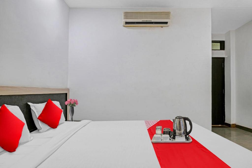 a bedroom with a white bed with red pillows at Super OYO Flagship 93079 Hotel Paradise in Varanasi