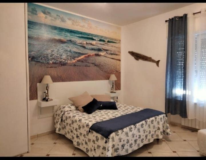 a bedroom with a bed and a painting on the wall at Bilocale e Monolocale Patrizia in Rio Marina