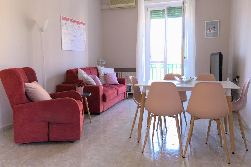 uma sala de estar com um sofá vermelho e uma mesa e cadeiras em Casa Gegè Lingotto em Turim