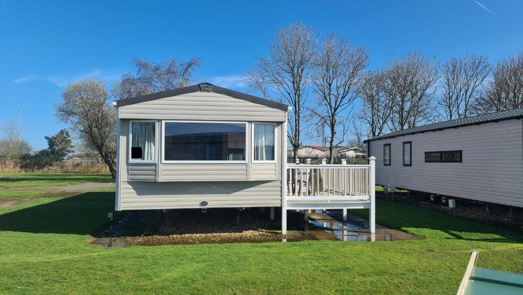 a tiny house with a porch in a yard at 8 Berth Luxury Caravan Butlins Holiday Village Skegness in Skegness