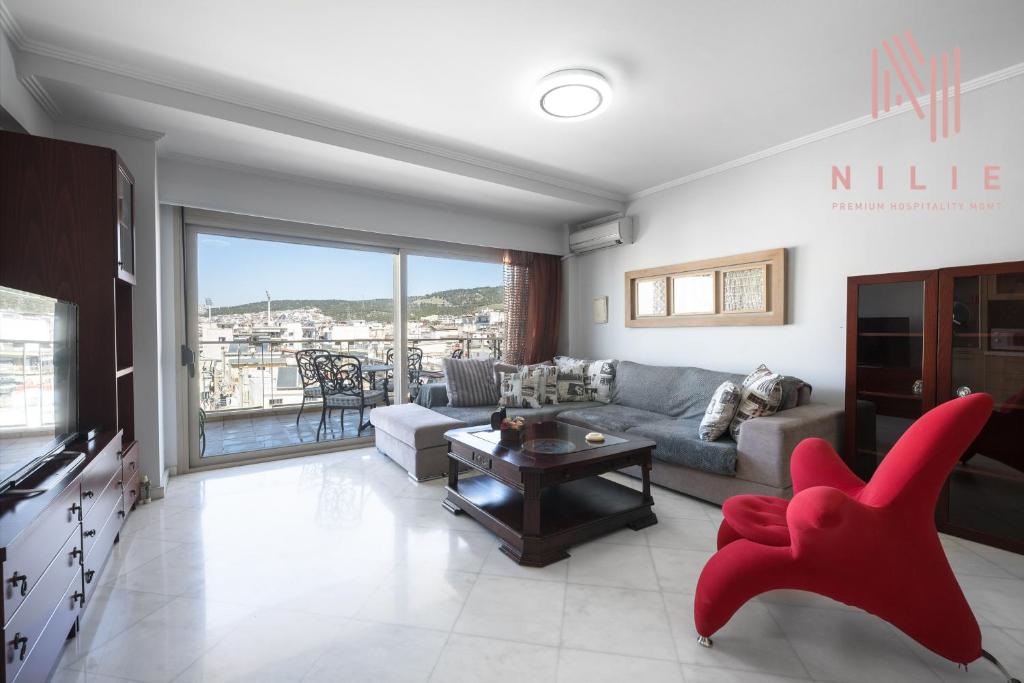 - un salon avec un canapé et un fauteuil rouge dans l'établissement Estrella, Nilie Hospitality MGMT, à Thessalonique