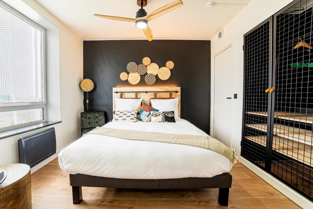 a bedroom with a bed with a black wall at COWOOL TOULOUSE in Toulouse