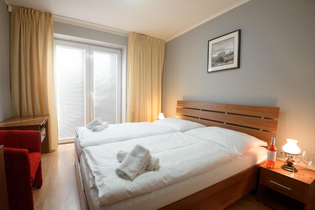 um quarto com uma grande cama branca com toalhas em Terra Wylak Winery em Veľké Zálužie