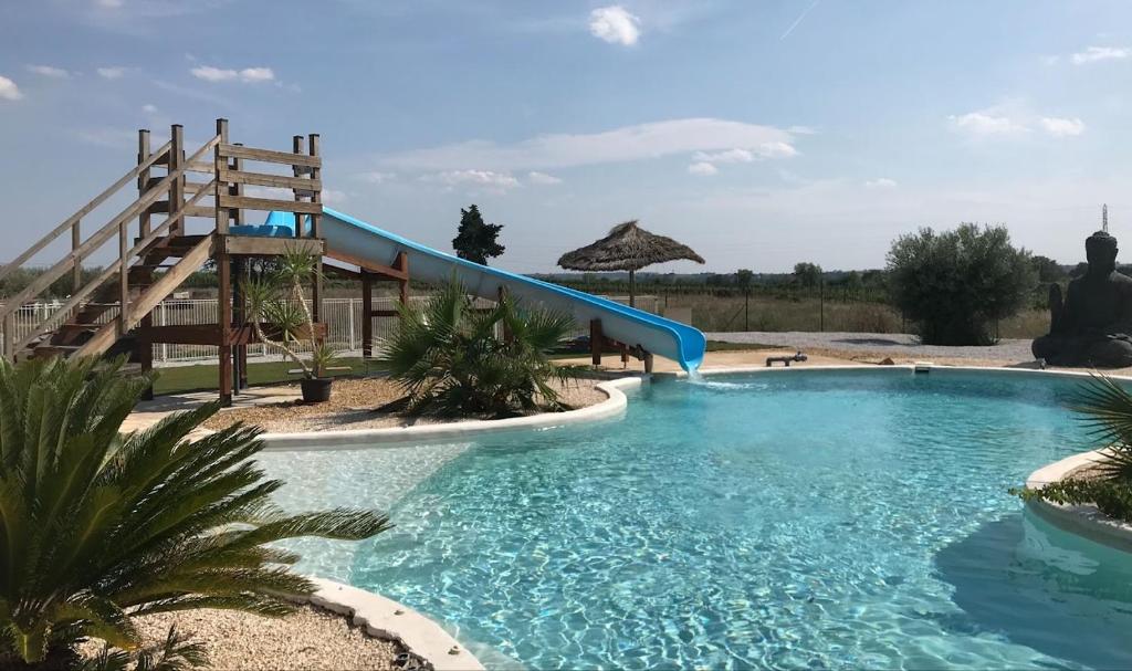 Cazouls-lès-Béziers的住宿－Chambres d'hotes Béziers La Noria，度假村内带滑梯的大型游泳池