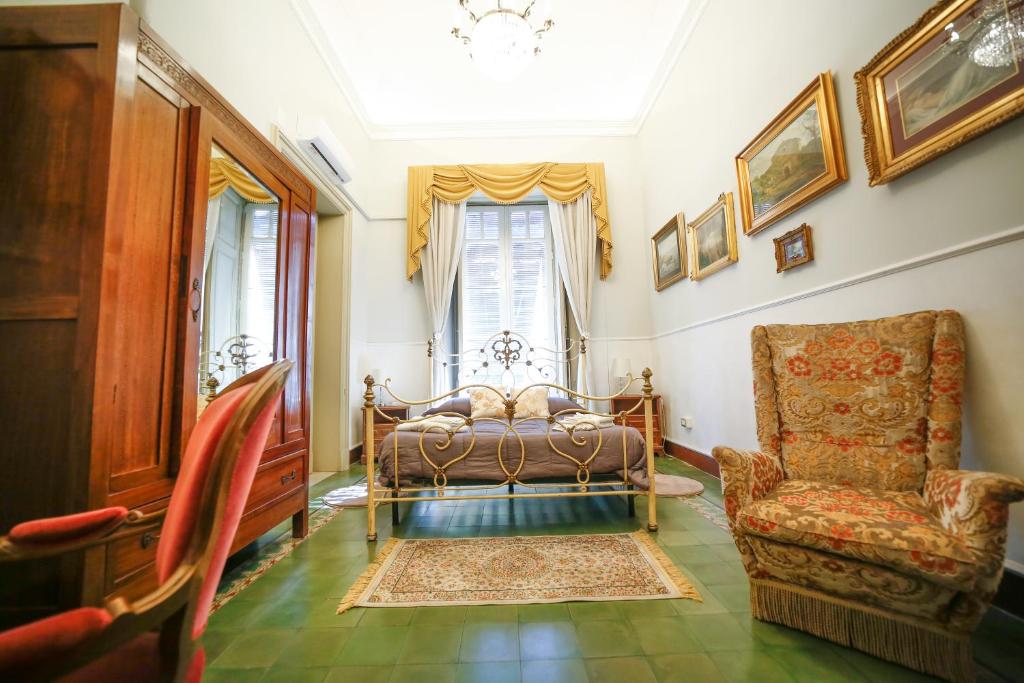 ein Schlafzimmer mit einem Bett, einem Stuhl und einem Fenster in der Unterkunft La casa di Marcello in Catania