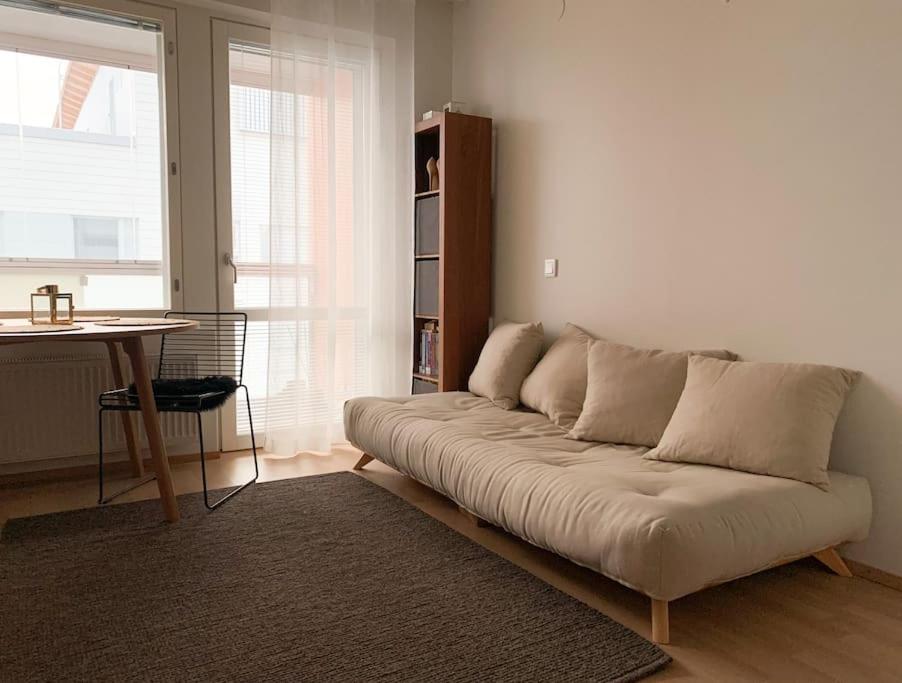 un sofá en una sala de estar con mesa en Anna's Stylish Studio apartment near Kerava train station en Kerava