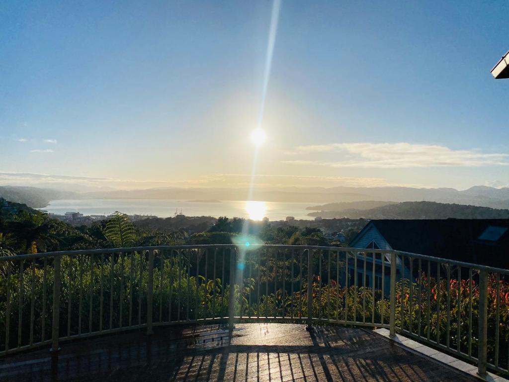 uma vista para o pôr-do-sol a partir de uma varanda em ROOM IN GREAT SEA VIEW HOUSE em Wellington